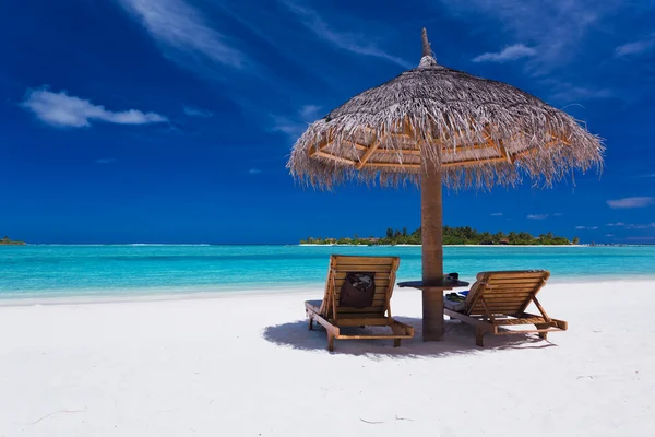 Two chairs and umbrella on stunning beach — Stock Photo, Image