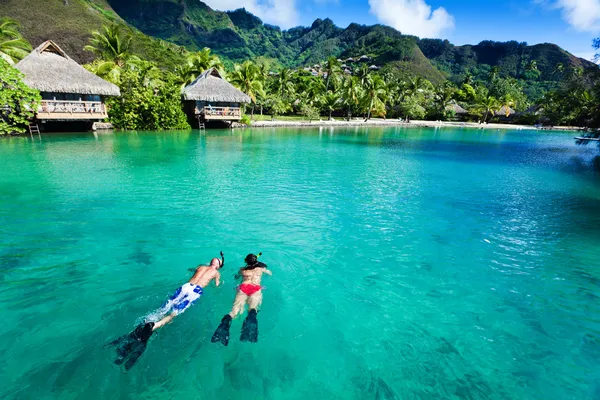 Jong koppel snorkelen in schoon water over koraal — Stockfoto
