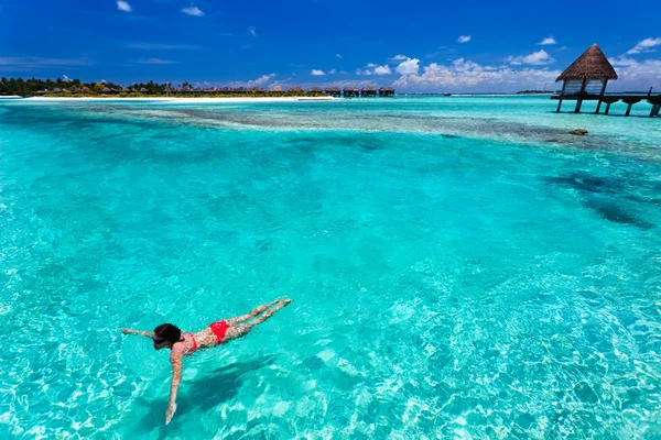 Femme en bikini rouge nageant dans un lagon de corail — Photo
