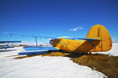 Old airplanes parked on a meadow with snow clipart