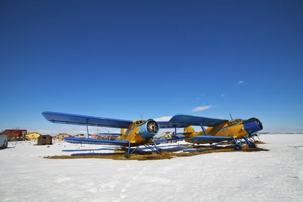 Старые самолеты, припаркованные на лугу со снегом — стоковое фото