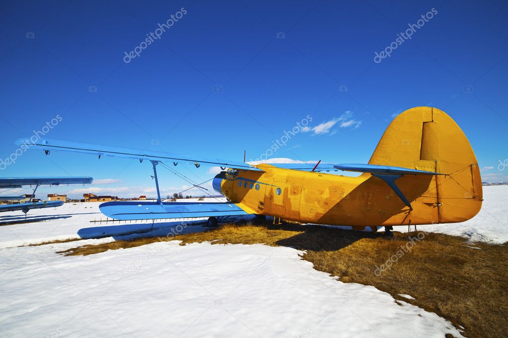 Old airplanes parked on a meadow with snow