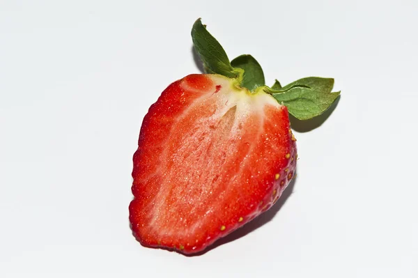 Schnitt und eine weitere rund um eine Erdbeere isoliert auf weißem Hintergrund — Stockfoto