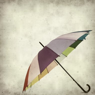 Textured old paper background with multicolored umbrella clipart