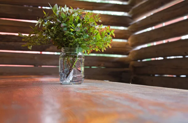 Ramas de arbusto de arándano en un frasco de vidrio utilizado como decoración de mesa — Foto de Stock