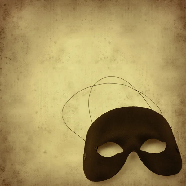 Texturizado fundo de papel velho com meia máscara de carnaval — Fotografia de Stock