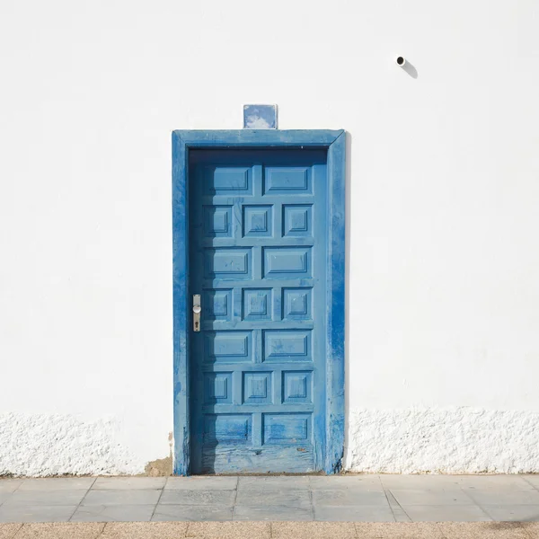 Архітектурні деталі - зів'ялі сині двері в побіленій стіні; ol — стокове фото