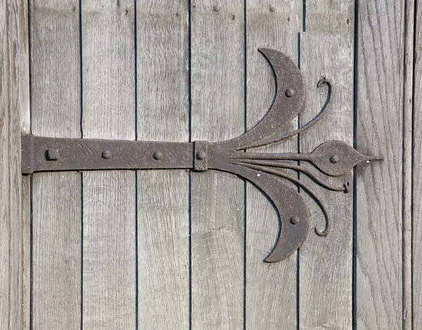 Ornamental hinges on old wooden door — Stock Photo, Image