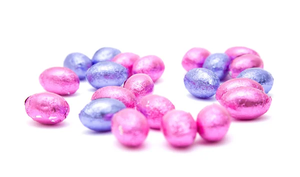 Čokoládová velikonoční vejce v růžové a lila fólie, izolované na bílém — Stock fotografie