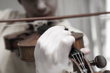 Child's hand playing a violin clipart