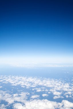 Mavi gökyüzü ışık bulutların üzerinde bir uçaktan görüntüleme