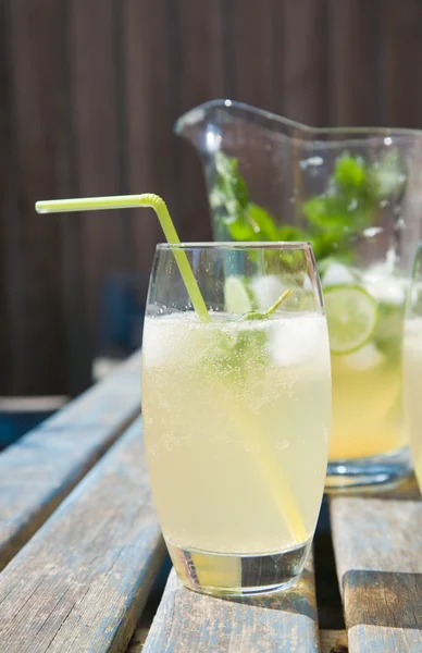 stock image Home-made cloudy lemonade with mint and lime; set outside in sun