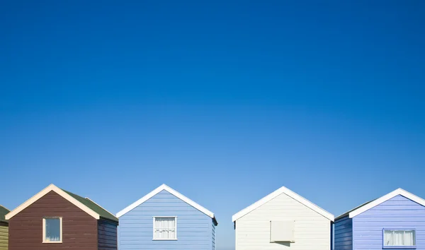 stock image Row of colorful beach huts under blue sky