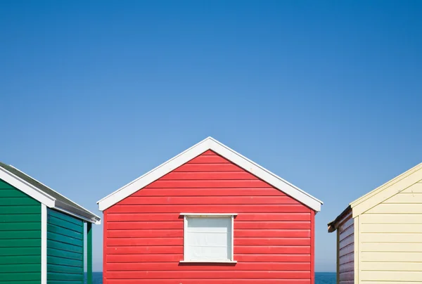 Row of colorful beach huts under blue sky — Stock Photo, Image