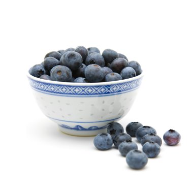 Fresh ripe blueberries in a small blue bowl, isolated on white background clipart