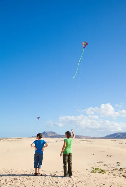Mor och son flyga en drake på naturreservatet Corralejos sanddyner, — Stockfoto