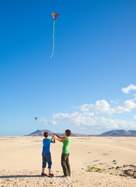 Moeder en zoon vliegen een vlieger in natuurreservaat dunes van corralejo, — Stockfoto
