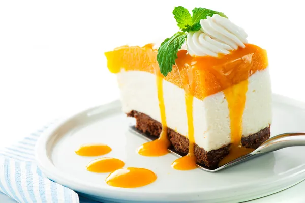 Ein Stück Mango-Käsekuchen auf weißem Hintergrund als Studio-Sho lizenzfreie Stockfotos