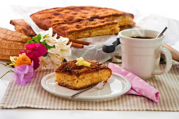 Ein Blechkuchen mit Zimtzuckerbutter und einer heißen Tasse Kaffee — Stockfoto