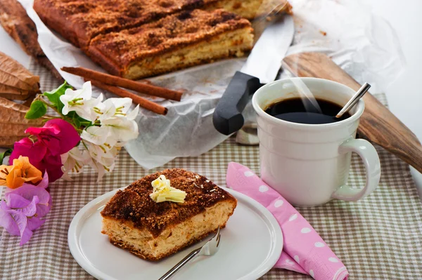 A sheet cake with cinnamon sugar butter and a hot cup of coffee — Stock Photo, Image