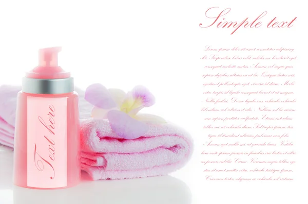 Розовые полотенца с цветком орхидеи и бутылка косметики на w — стоковое фото