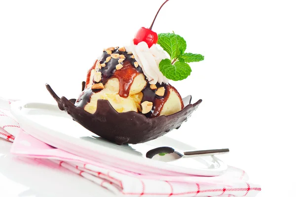 Vanille ijs met karamel, chocolade saus, noten en kers in een — Stockfoto