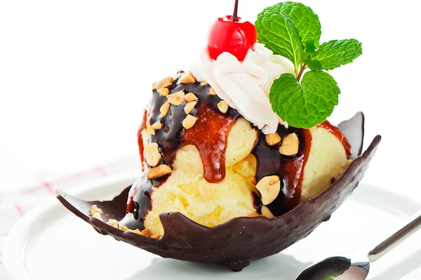 Gelo de baunilha com caramelo, molho de chocolate, nozes e cereja em um — Fotografia de Stock