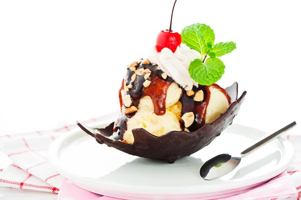 Vanilla ice with caramel, chocolate sauce, nuts and cherry in a — Stock Photo, Image
