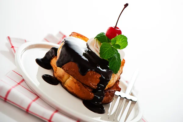 Tostadas francesas con chocolate negro, crema blanca, cereza roja y un —  Fotos de Stock