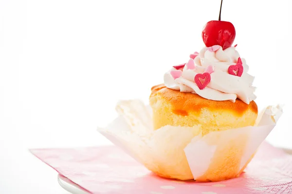 Vanilj cupcake med vit grädde hjärta som dekoration och en cherr — Stockfoto