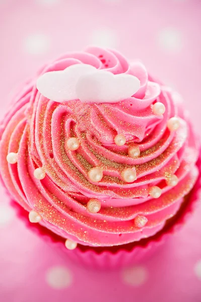 Ένα cupcake σε ένα ροζ ψήσιμο κύπελλα με ροζ κρέμα, λευκό παιχνίδι — Φωτογραφία Αρχείου