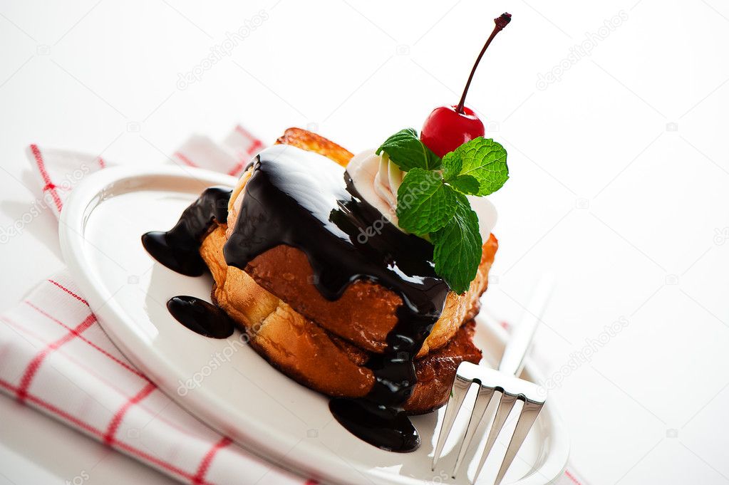 French toast with dark chocolate, white cream, red cherry and a