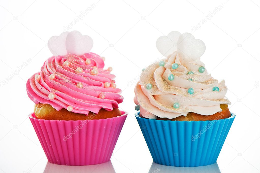 Two cupcakes in a pink and blue baking cups with pink and white