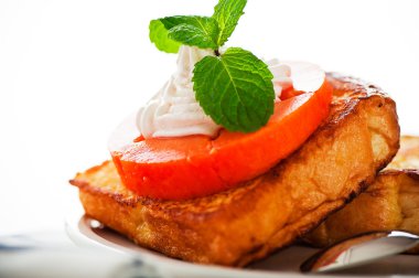 iki dilim tost papaya, krema ve nane yaprağı ile bir
