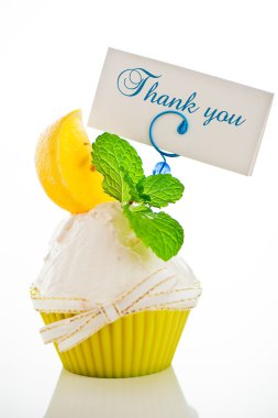 A refreshing lemon cupcake with a leaf of mint and a label for y clipart