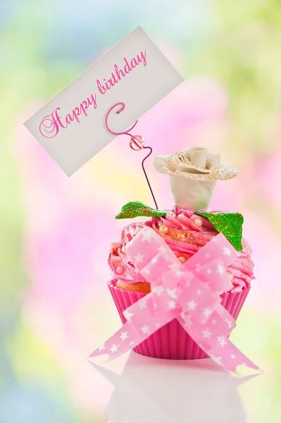Um lindo bolo de aniversário feliz rosa com flor e um rótulo — Fotografia de Stock