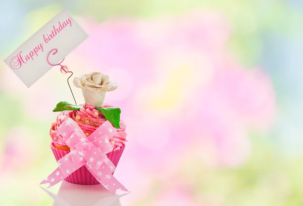A beautiful pink happy birthday cupcake with flower and a label — Stock Photo, Image