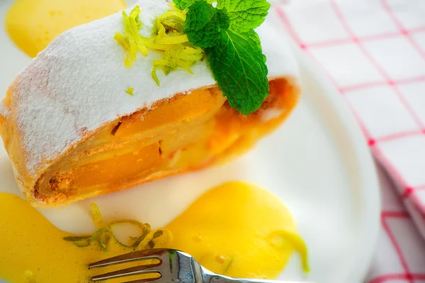 A piece of banana, mango strudel with vanilla sauce and lemon on — Stock Photo, Image
