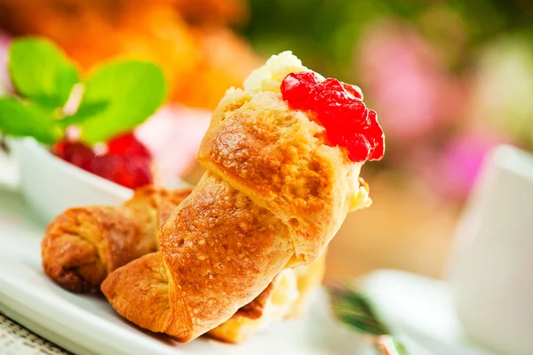 Utomhus frukost med färska croissanter, kaffe, marmelad och blommor en — Stockfoto