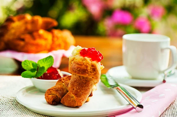 Desayuno al aire libre con café cruasán fresco, mermelada y flores a — Foto de Stock