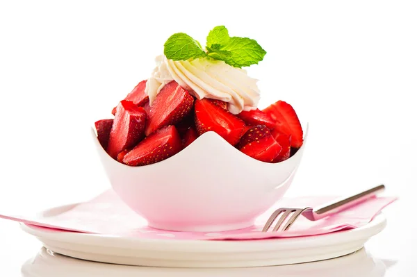 Fresas en un tazón blanco con crema y hoja de menta en la parte superior —  Fotos de Stock