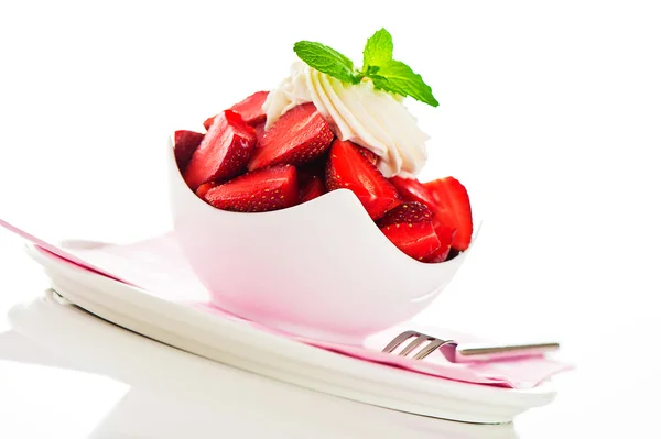 Strawberries in a white bowl with cream and mint leaf on the top — Stock Photo, Image