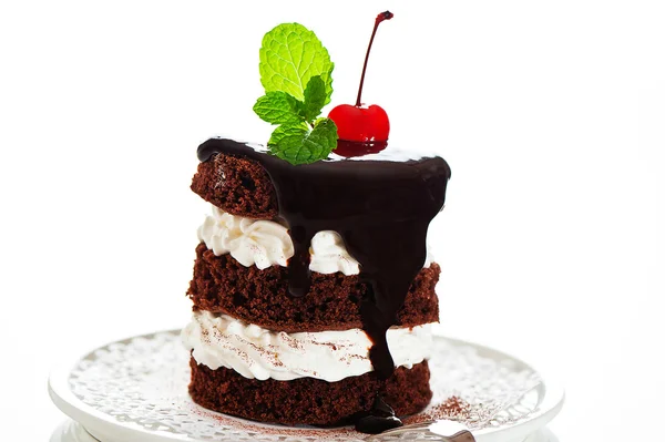 Un pequeño pastel de chocolate con 2 capas de crema blanca, cereza y menta — Foto de Stock