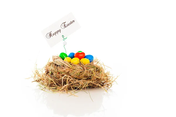 A nest with easter eggs and a label with happy esater on white b — Stock Photo, Image