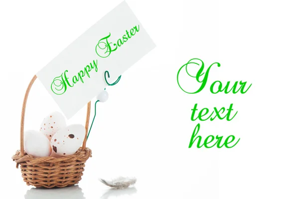 Маленький кошик з яйцями та етикеткою для вашого тексту на білому фоні — стокове фото