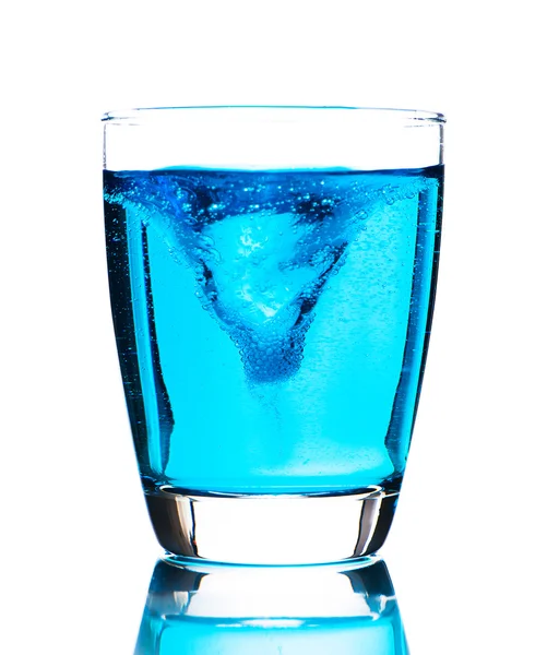 Склянка зі світло-блакитною водою на білому тлі як студія ш — стокове фото