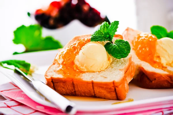 Desayuno con mantequilla tostada francesa y mermelada en un plato blanco — Foto de Stock