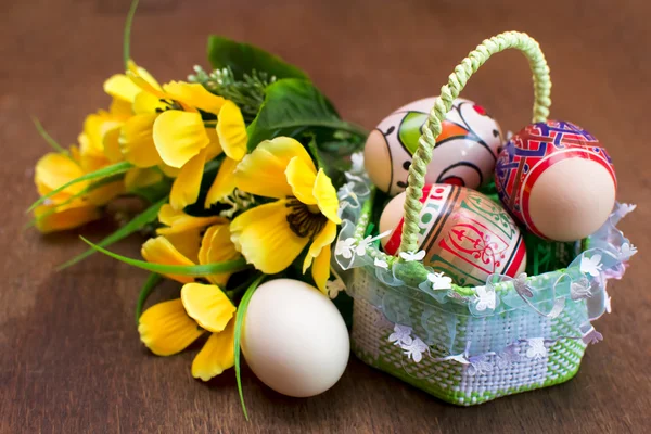 Uova di Pasqua in cesto su sfondo di legno — Foto Stock