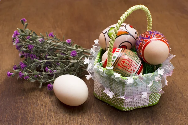 Velikonoční vejce v košíku na dřevěném pozadí — Stock fotografie