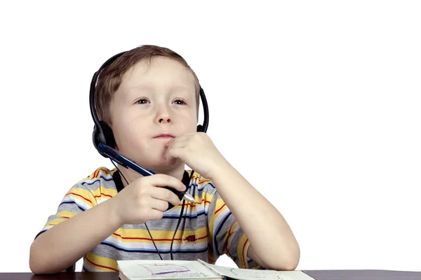 A little boy thinks the headphones with microphone — Stock Photo, Image